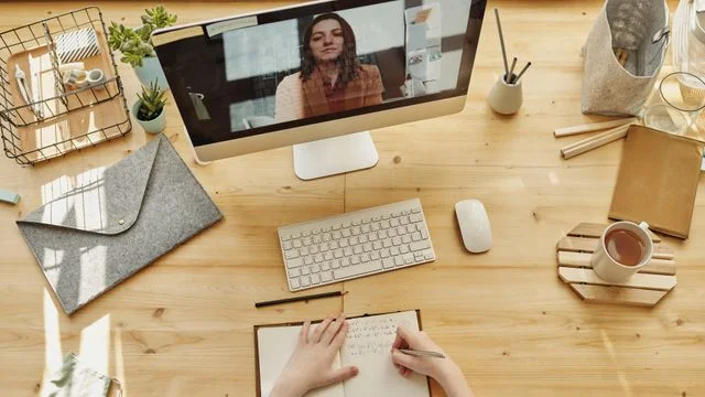 Online lesson on a desktop computer with study notes