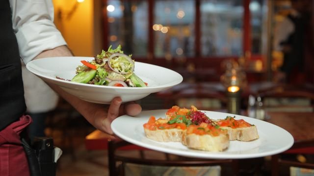 Restaurant server carrying freshly prepared dishes