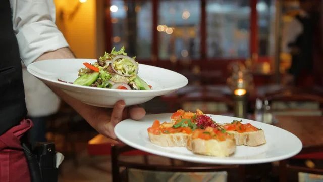 Restaurant server carrying freshly prepared dishes